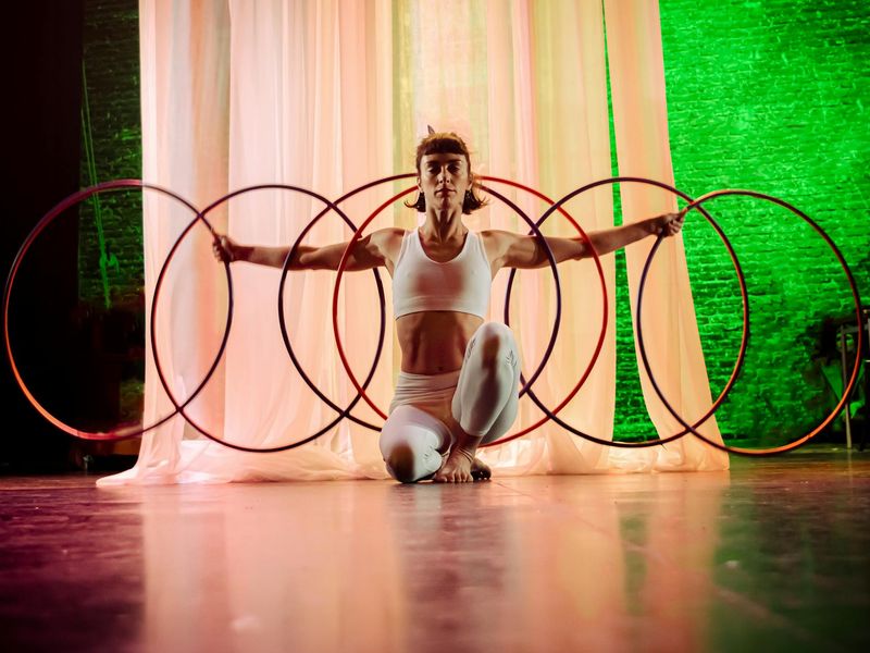Woman performing a focused yoga movement in a bright studio.